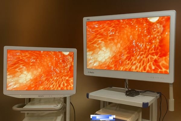 A surgeon pointing confidently at a detail on a surgical display during a procedure