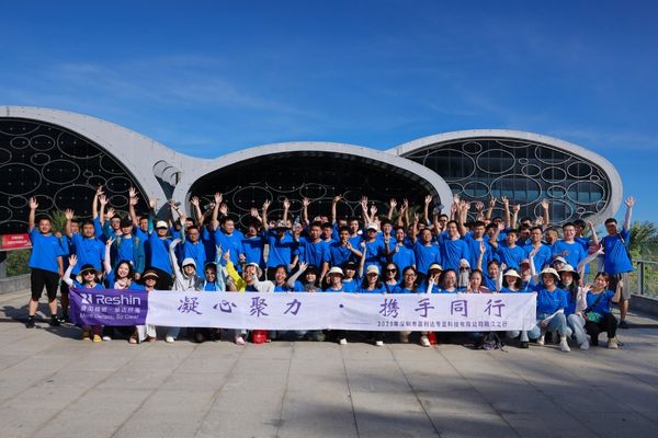 Reshin 2024 Hailing Island team building event, employees in blue uniforms group photo