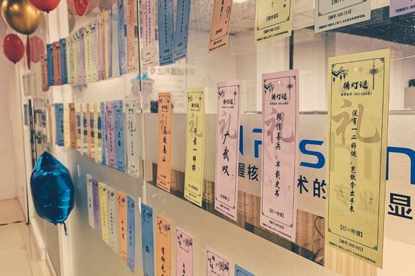 Reshin Lantern Festival riddle event, colorful riddle cards hanging on glass wall