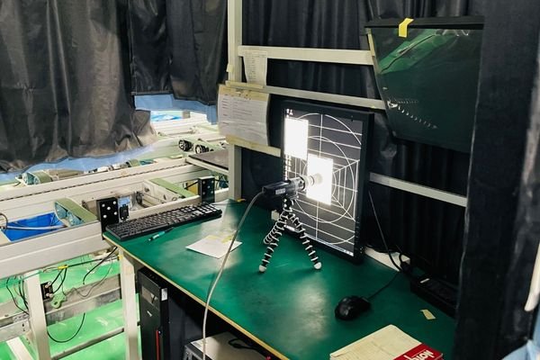 A medical physicist conducting a DICOM conformance test on a PACS monitor using a photometer.