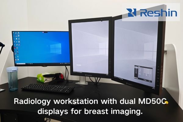 A radiology workstation showing dual Reshin MD50C displays reviewing mammography and ultrasound studies