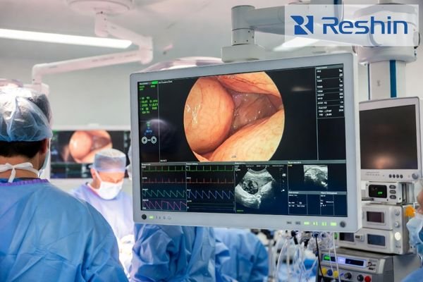 Surgical team using an advanced multi-source display system showing endoscopic imaging and vital data