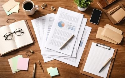 Procurement and engineering documentation on a desk, showing reports, charts, and checklists used for OEM medical display project planning and compliance coordination.