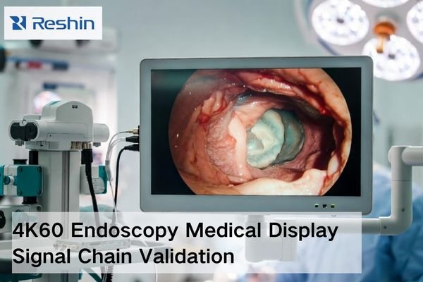 Medical-grade endoscopy monitor on an OR cart showing a stable endoscopic image while the 4K60 signal chain is validated with secure cabling and a test device.