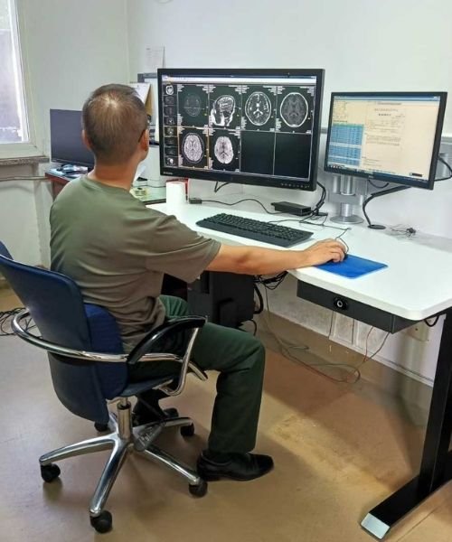 Radiology workstation with multiple diagnostic displays showing medical imaging during workstation evaluation