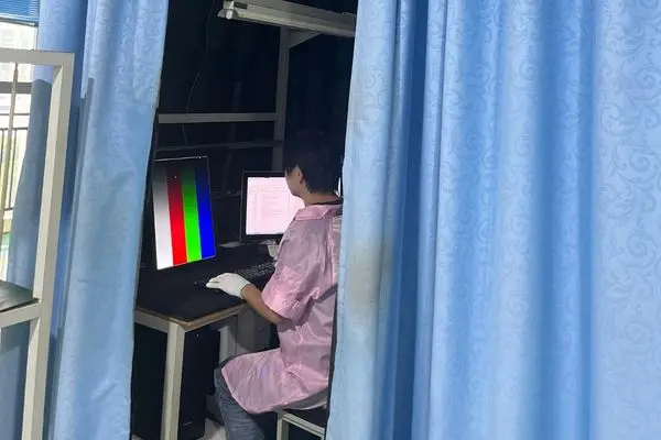 Reshin technician conducting final quality control inspection on a medical display