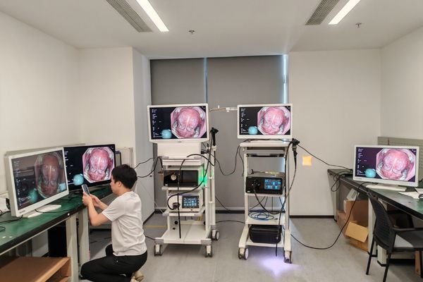 Engineer checking connected surgical displays and endoscopy equipment during system integration debugging